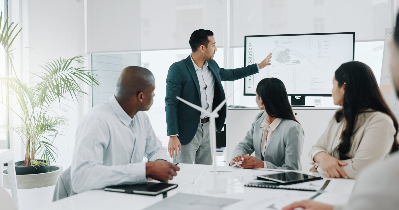 People, teamwork and wind turbine presentation for renewable energy, eco friendly business and sustainability planning. Engineering manager, meeting and collaboration for windmill model or 3d design.